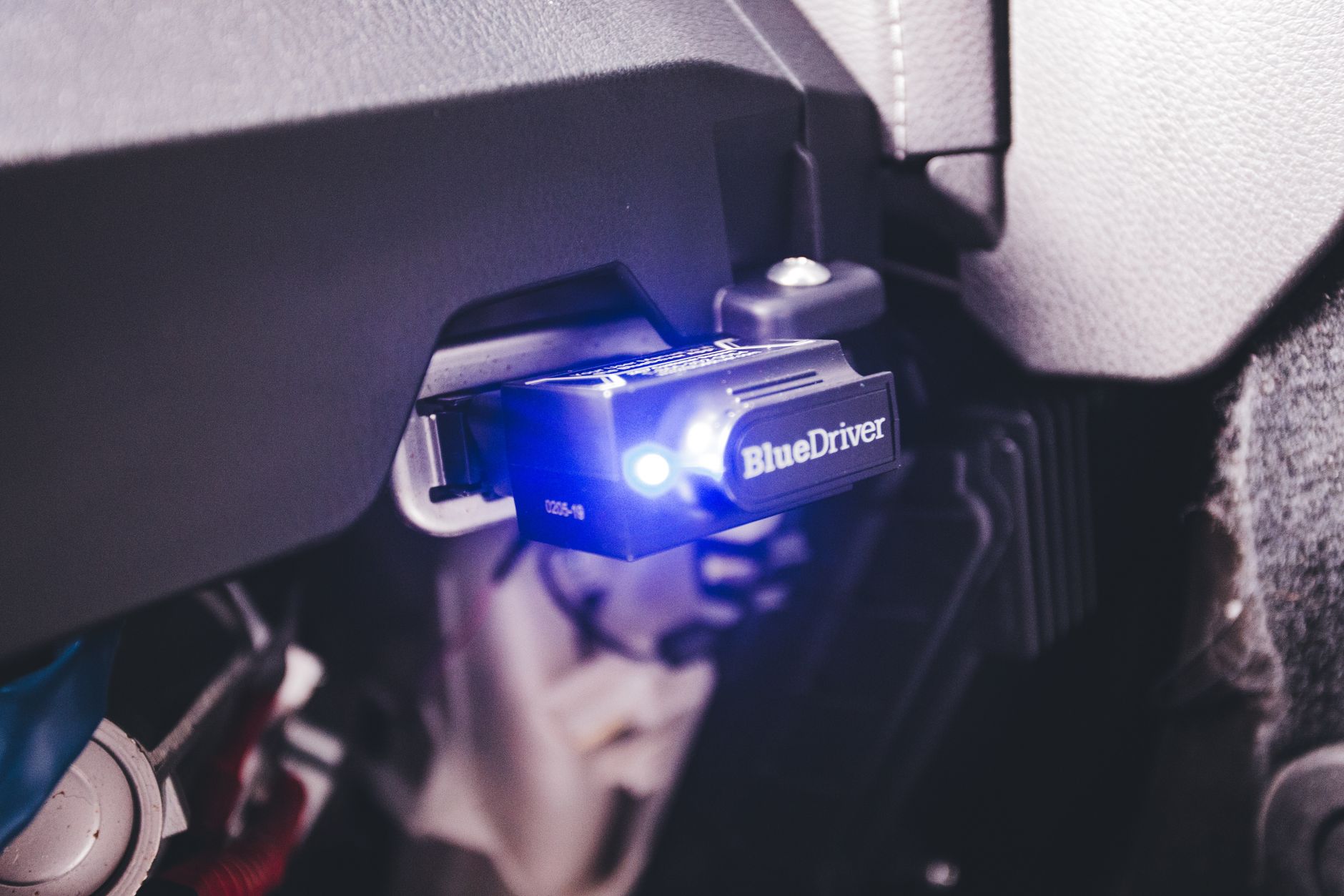 A diagnostic scanner plugged into a car, close up